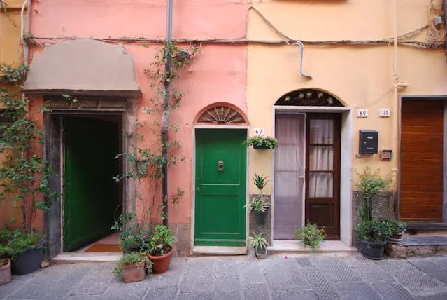 a row of colorful buildings with green doors