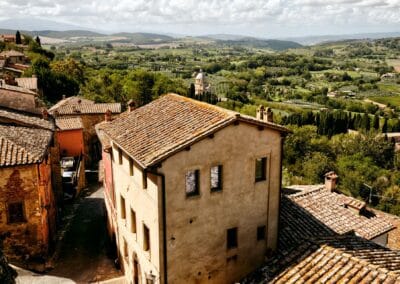buildings with a view of a Tuscan valley and trees