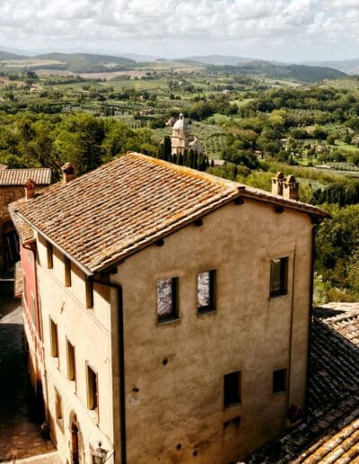 buildings with a view of a Tuscan valley and trees