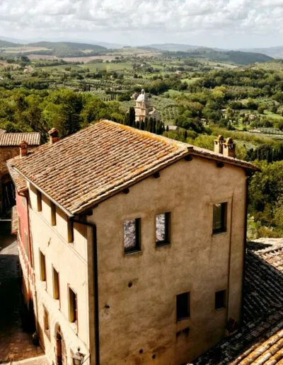 buildings with a view of a Tuscan valley and trees
