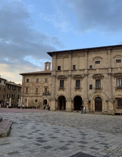 a stone building with a stone square in Montepulciano